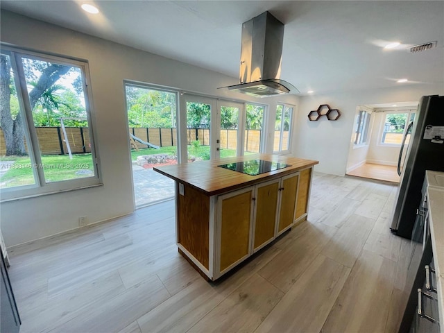 1930 NE 178th St, North Miami Beach, FL 33162 - kitchen with island range hood, freestanding refrigerator, black electric stovetop, butcher block countertops, and a center island