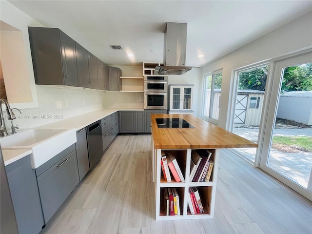 1930 NE 178th St, North Miami Beach, FL 33162 - kitchen with open shelves, gray cabinetry, island range hood, wooden counters, and plenty of natural light