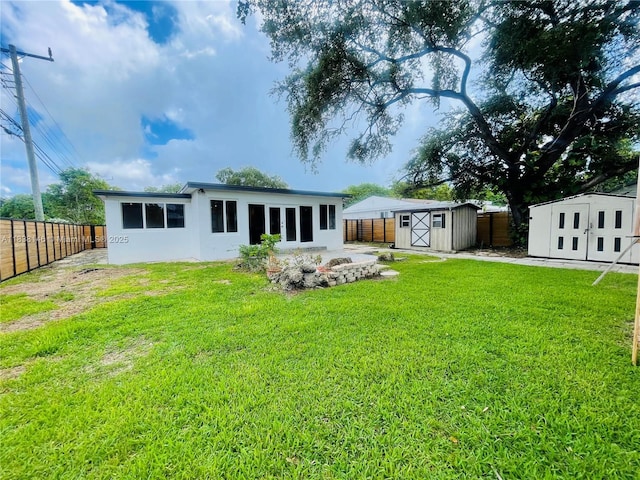 1930 NE 178th St, North Miami Beach, FL 33162 - rear view of property with a shed, a fenced backyard, a fire pit, and stucco siding
