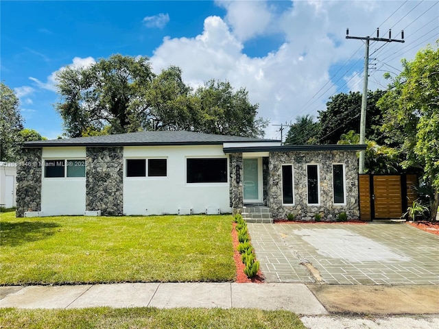 1930 NE 178th St, North Miami Beach, FL 33162 - view of front of property with stone siding, stucco siding, and a patio