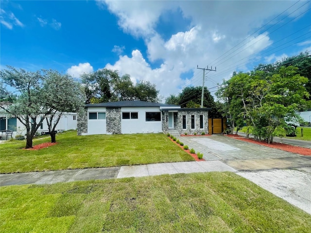 1930 NE 178th St, North Miami Beach, FL 33162 - view of front of property with stone siding, driveway, and a front lawn