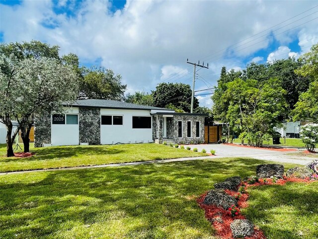 1930 NE 178th St, North Miami Beach, FL 33162 - view of front facade with stone siding, a front yard, driveway, and stucco siding