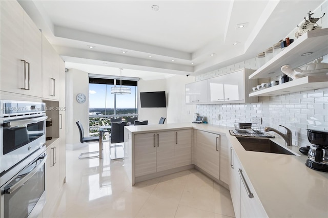 2000 Island Blvd Unit 2409, Aventura, FL 33160 - kitchen featuring double oven, decorative backsplash, modern cabinets, a peninsula, and light countertops