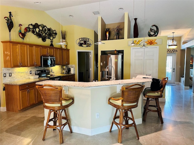 kitchen featuring black range with electric stovetop, stainless steel fridge with ice dispenser, brown cabinetry, backsplash, and a kitchen bar