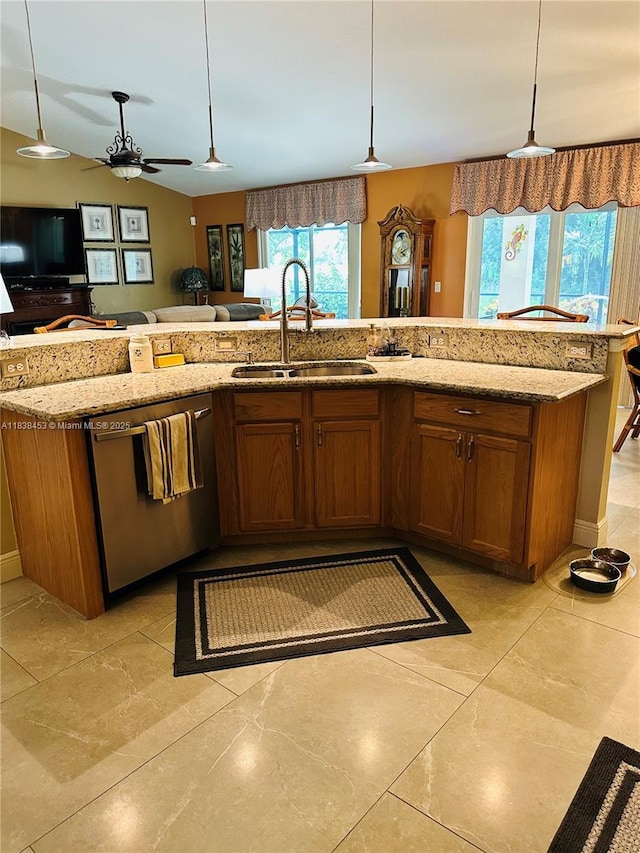 kitchen with stainless steel dishwasher, brown cabinetry, ceiling fan, and light stone counters