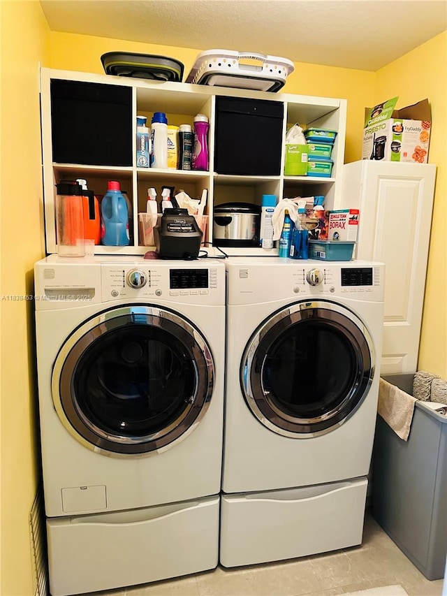 laundry room with separate washer and dryer and light tile patterned floors