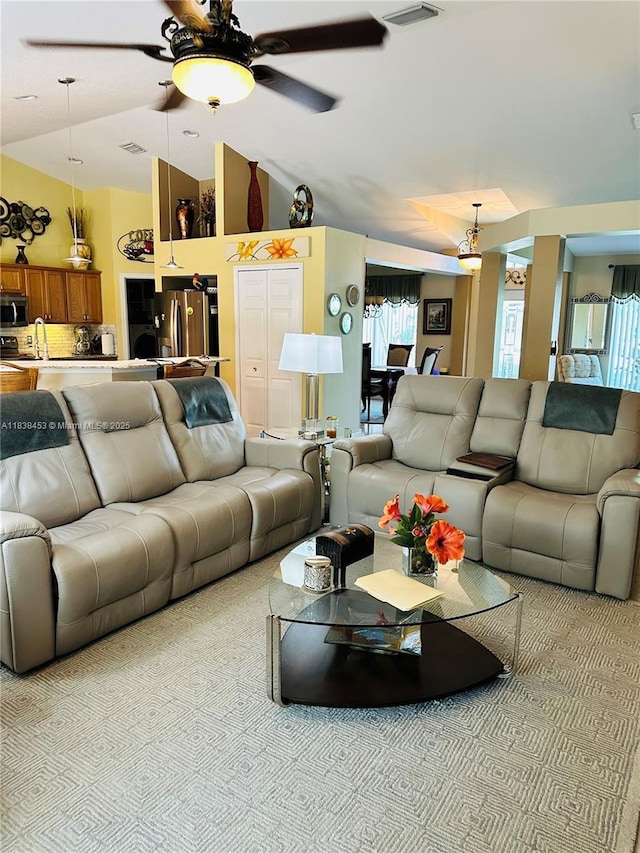 living area featuring healthy amount of natural light, ceiling fan, carpet floors, and high vaulted ceiling