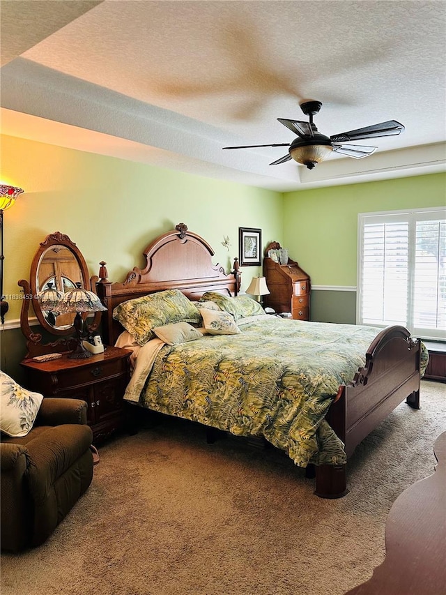 carpeted bedroom with ceiling fan and a textured ceiling