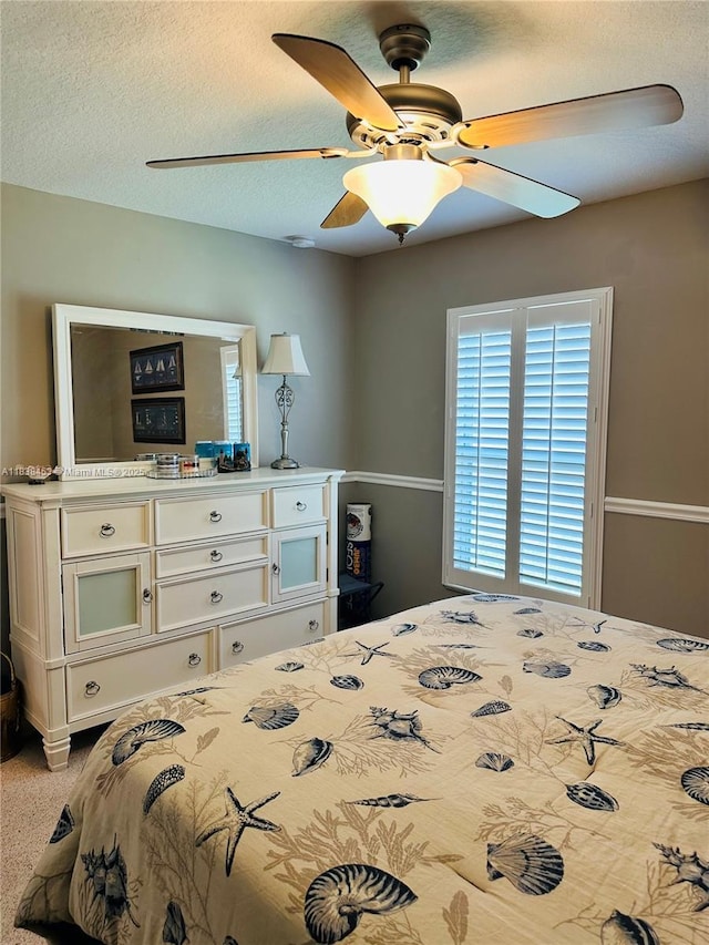 bedroom featuring a ceiling fan and a textured ceiling
