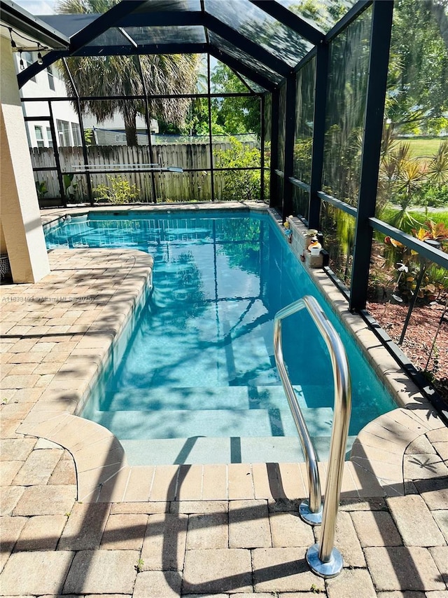view of swimming pool featuring a lanai and a patio area