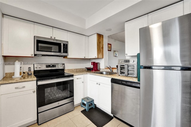 7684 NW 18th St Unit 202, Margate, FL 33063 - kitchen with appliances with stainless steel finishes, light tile patterned floors, and white cabinets