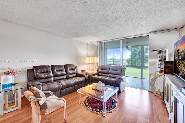 7684 NW 18th St Unit 202, Margate, FL 33063 - living area featuring wood finished floors, a textured ceiling, and floor to ceiling windows