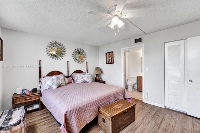 7684 NW 18th St Unit 202, Margate, FL 33063 - bedroom with light wood-type flooring, a textured ceiling, ceiling fan, and connected bathroom