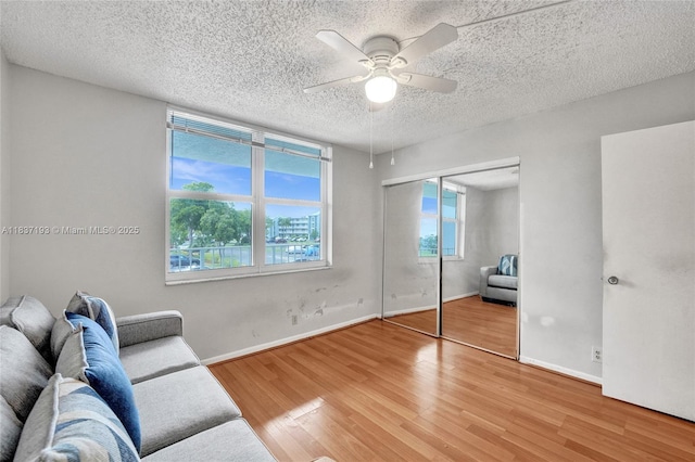 7684 NW 18th St Unit 202, Margate, FL 33063 - living room with light wood-style floors, a ceiling fan, and a textured ceiling