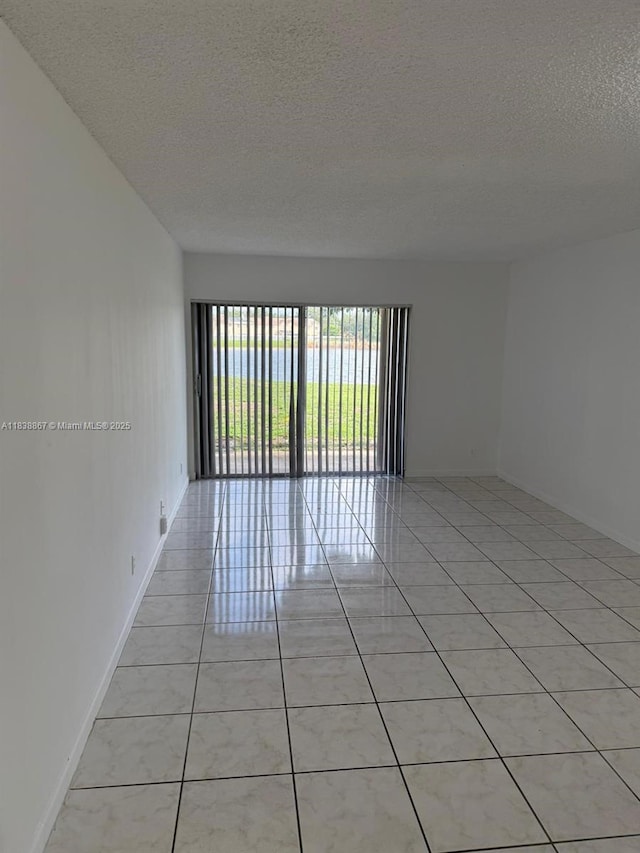8560 N Sherman Cir Unit 105, Miramar, FL 33025 - unfurnished room with a textured ceiling and light tile patterned flooring