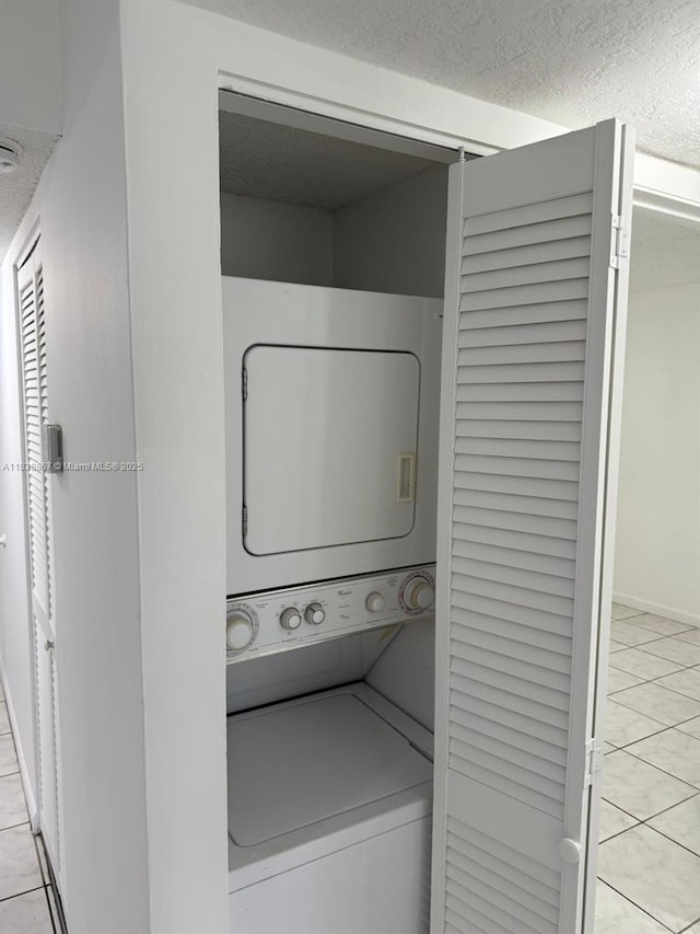 8560 N Sherman Cir Unit 105, Miramar, FL 33025 - washroom with stacked washer and clothes dryer, tile patterned floors, and a textured ceiling