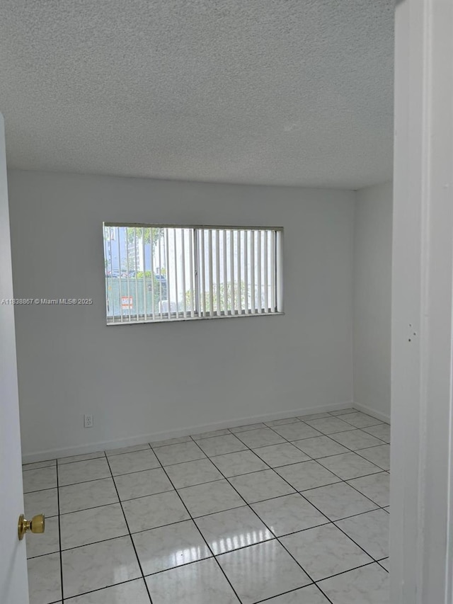 8560 N Sherman Cir Unit 105, Miramar, FL 33025 - tiled spare room with healthy amount of natural light and a textured ceiling