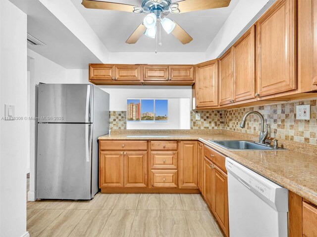 1170 NE 191st St Unit 24, Miami, FL 33179 - kitchen featuring freestanding refrigerator, white dishwasher, a ceiling fan, decorative backsplash, and brown cabinets
