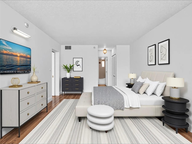 1170 NE 191st St Unit 24, Miami, FL 33179 - bedroom featuring wood finished floors and a textured ceiling