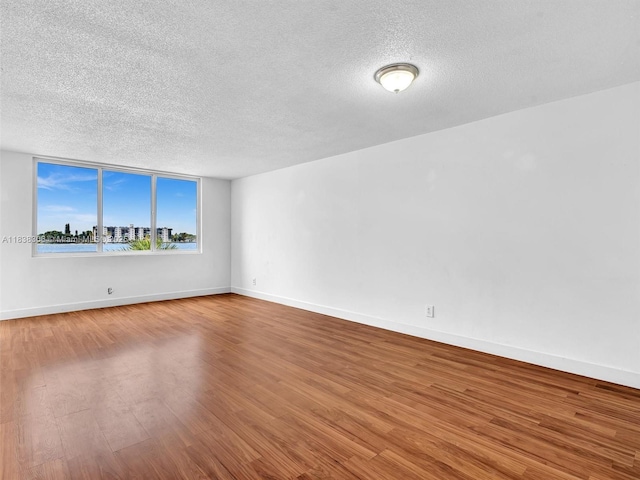 1170 NE 191st St Unit 24, Miami, FL 33179 - spare room featuring a textured ceiling and wood finished floors