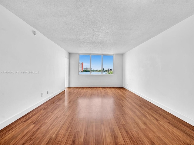 1170 NE 191st St Unit 24, Miami, FL 33179 - empty room featuring a textured ceiling and wood finished floors