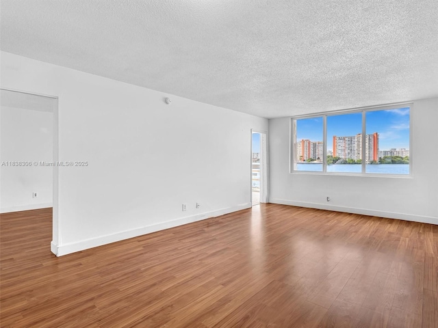 1170 NE 191st St Unit 24, Miami, FL 33179 - spare room featuring a textured ceiling and wood finished floors