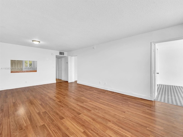 1170 NE 191st St Unit 24, Miami, FL 33179 - spare room with a textured ceiling and wood finished floors