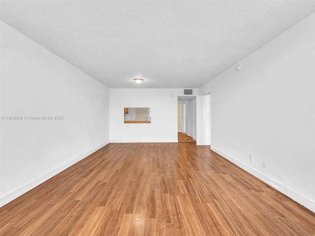 1170 NE 191st St Unit 24, Miami, FL 33179 - empty room featuring a textured ceiling and light wood finished floors