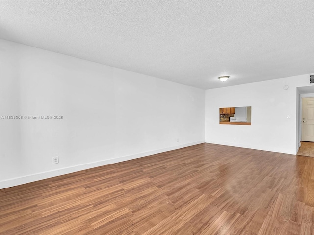 1170 NE 191st St Unit 24, Miami, FL 33179 - spare room with wood finished floors and a textured ceiling