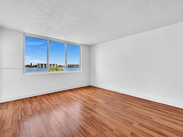 1170 NE 191st St Unit 24, Miami, FL 33179 - unfurnished room with a textured ceiling and wood finished floors