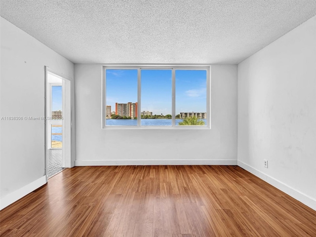 1170 NE 191st St Unit 24, Miami, FL 33179 - spare room featuring a textured ceiling and wood finished floors