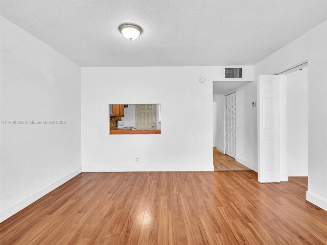 1170 NE 191st St Unit 24, Miami, FL 33179 - unfurnished room featuring light wood-style flooring and a textured ceiling
