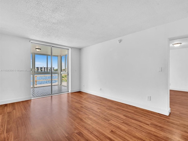 1170 NE 191st St Unit 24, Miami, FL 33179 - spare room with a textured ceiling, wood finished floors, and floor to ceiling windows