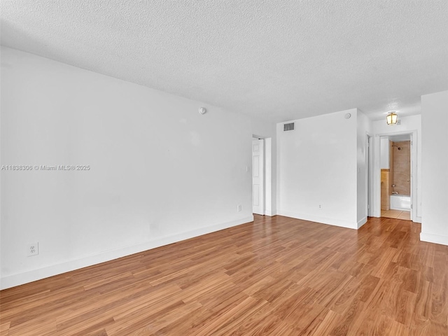 1170 NE 191st St Unit 24, Miami, FL 33179 - spare room featuring a textured ceiling and light wood-type flooring