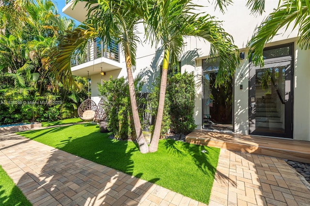 909 NE 16th Ter, Fort Lauderdale, FL 33304 - entrance to property with stucco siding, a balcony, and a yard