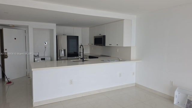 1450 Brickell Bay Dr Unit 1402, Miami, FL 33131 - kitchen featuring stainless steel appliances, a peninsula, light countertops, and white cabinets