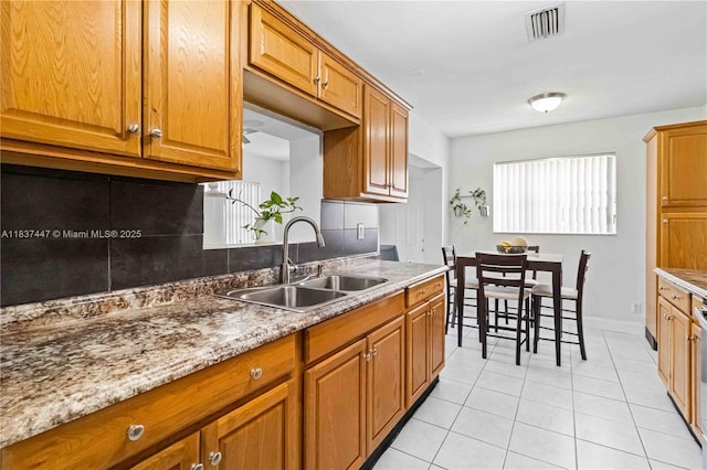 5723 NW 86th Ave, Tamarac, FL 33321 - kitchen featuring light tile patterned flooring, tasteful backsplash, and brown cabinetry