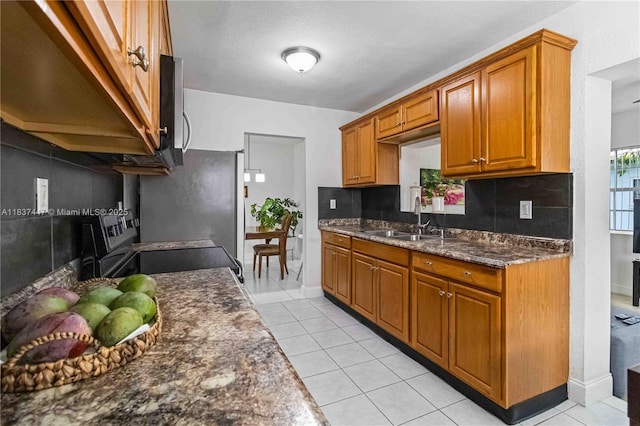 5723 NW 86th Ave, Tamarac, FL 33321 - kitchen with tasteful backsplash, light tile patterned floors, brown cabinets, range, and stainless steel microwave