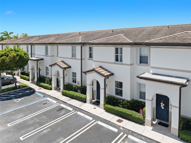 8079 W 36th Ave Unit 6, Hialeah, FL 33018 - view of front facade featuring uncovered parking, a tile roof, and stucco siding