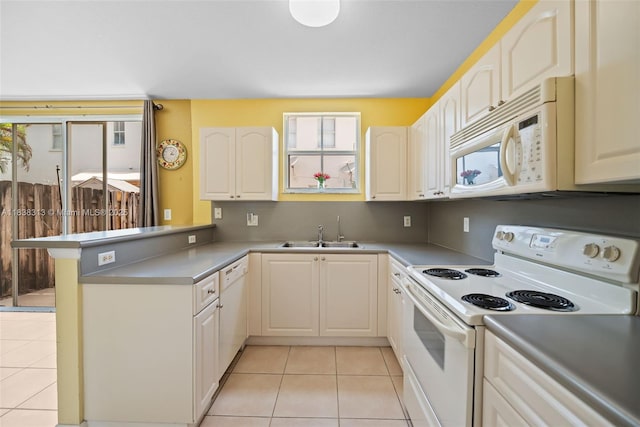 8079 W 36th Ave Unit 6, Hialeah, FL 33018 - kitchen featuring white appliances, plenty of natural light, a peninsula, and light tile patterned floors