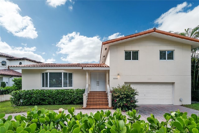 5308 Riviera Dr, Coral Gables, FL 33146 - view of front of house with a tiled roof, decorative driveway, an attached garage, and stucco siding