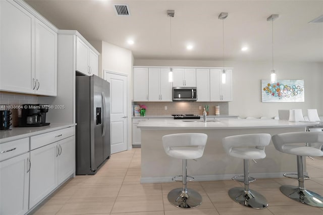 8036 NW 78th St, Tamarac, FL 33321 - kitchen featuring stainless steel appliances, backsplash, a breakfast bar area, white cabinetry, and recessed lighting