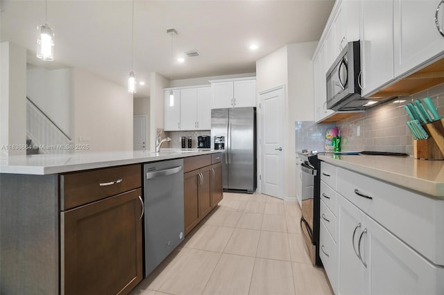 8036 NW 78th St, Tamarac, FL 33321 - kitchen with appliances with stainless steel finishes, decorative backsplash, light countertops, light tile patterned flooring, and white cabinetry