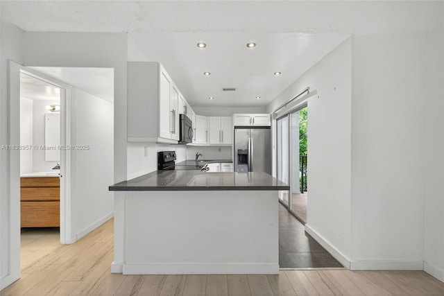1821 Jefferson Ave Unit 202, Miami Beach, FL 33139 - kitchen with stainless steel refrigerator with ice dispenser, electric stove, light wood-style flooring, recessed lighting, and dark countertops