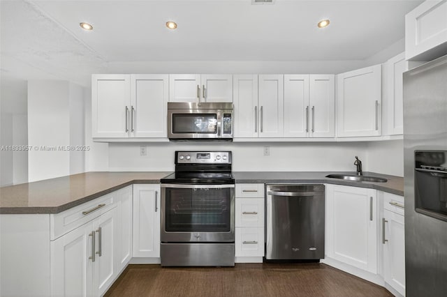 1821 Jefferson Ave Unit 202, Miami Beach, FL 33139 - kitchen featuring stainless steel appliances, a peninsula, dark countertops, white cabinets, and recessed lighting