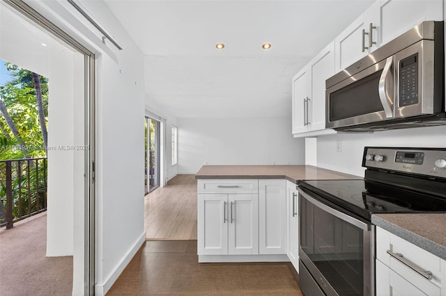 1821 Jefferson Ave Unit 202, Miami Beach, FL 33139 - kitchen with stainless steel appliances, white cabinets, a peninsula, and recessed lighting