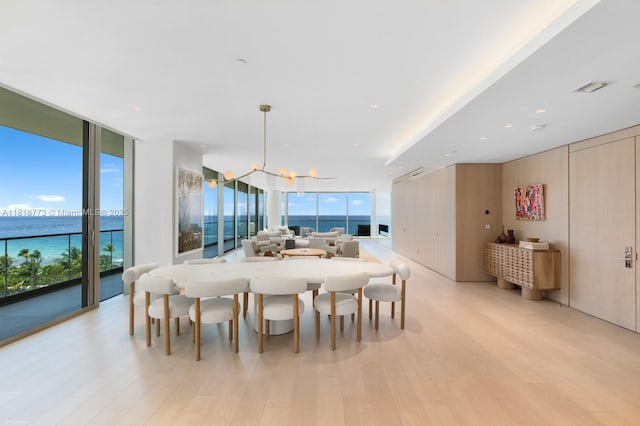 10203 Collins Ave Unit 701, Bal Harbour, FL 33154 - dining area with a wall of windows, healthy amount of natural light, light wood-style flooring, a water view, and a chandelier