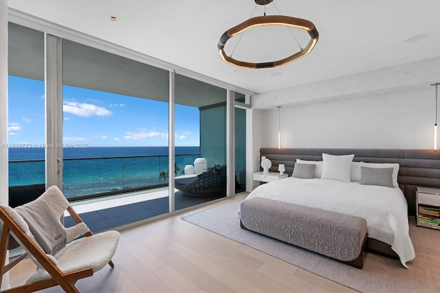 10203 Collins Ave Unit 701, Bal Harbour, FL 33154 - bedroom with a wall of windows, wood finished floors, and a water view