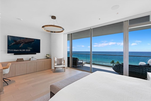10203 Collins Ave Unit 701, Bal Harbour, FL 33154 - bedroom with a wall of windows, wood finished floors, access to outside, and a water view