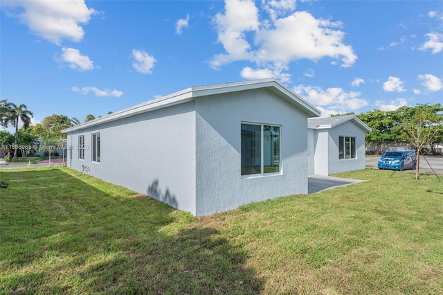 3451 SW 19th St, Fort Lauderdale, FL 33312 - view of side of property with stucco siding and a lawn